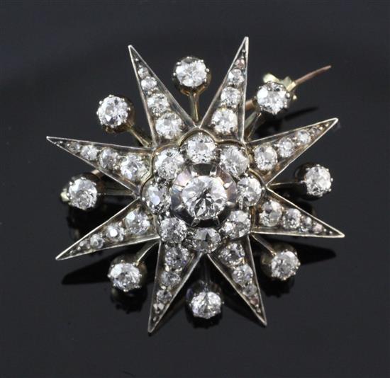 An early 20th century gold and silver, diamond starburst pendant brooch, approx. 1in.